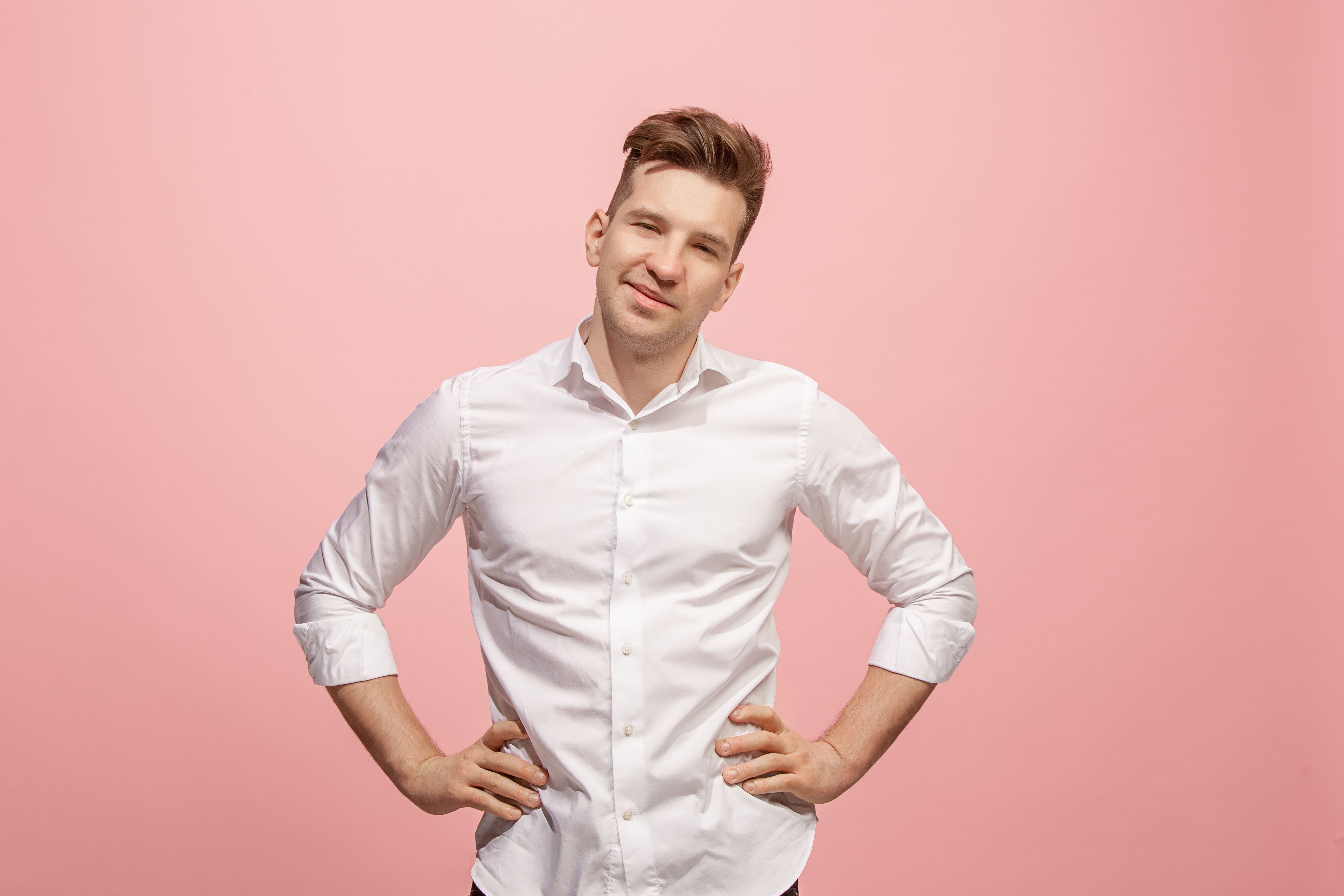 happy-business-man-standing-smiling-against-pink